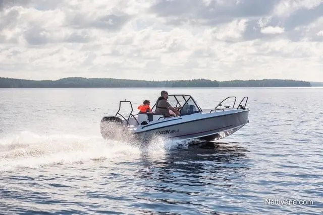 A man and a child in life jackets are riding in a boat on a lake, creating a splash against a cloudy sky.